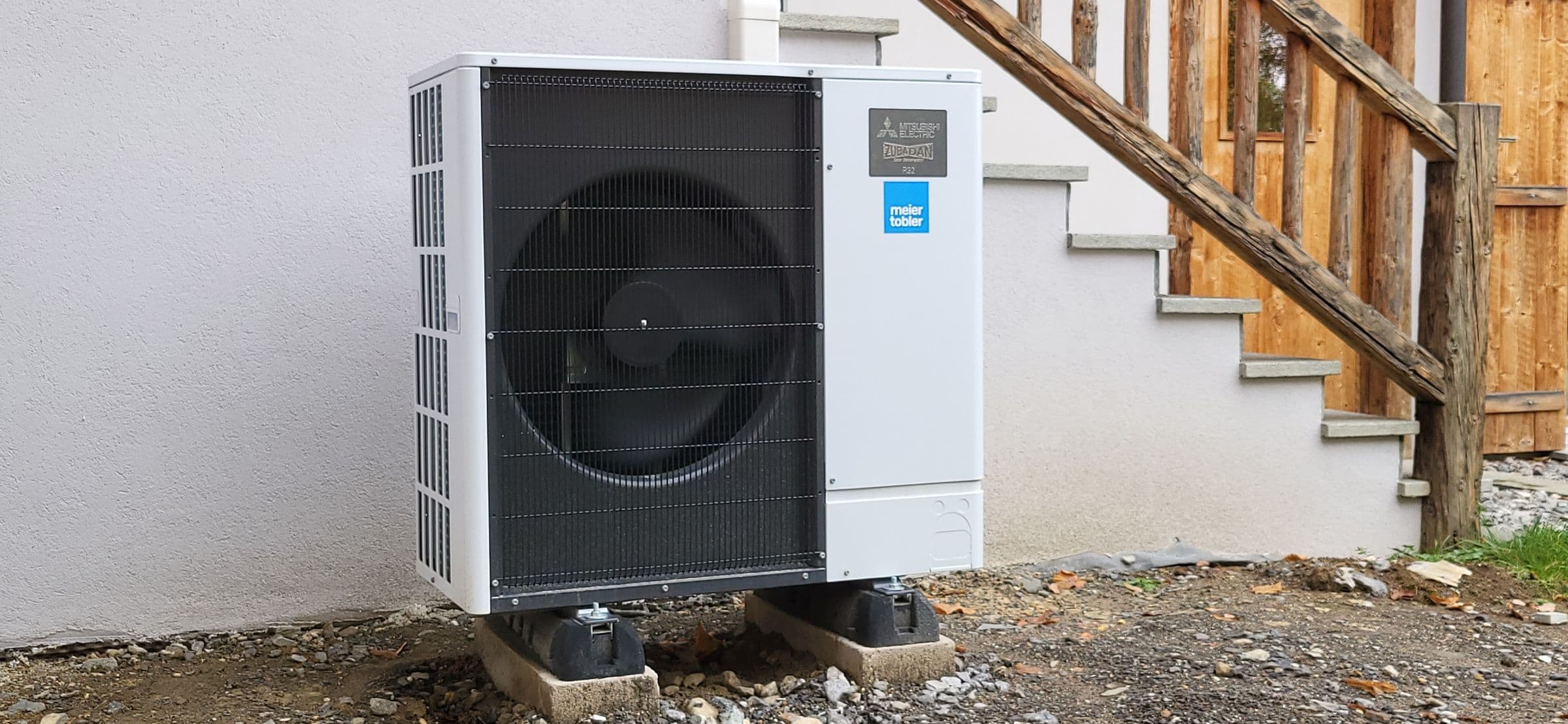 Pompe à chaleur air-eau Mitsubishi Electric au pied d'un chalet à Ollon, canton de Vaud